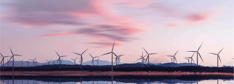 windmils at water during sunset